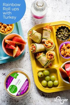 an assortment of fruits and vegetables on a tray with the words rainbow rolls with turkey