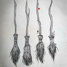 four different types of brooms hanging from branches with one red dot in the middle