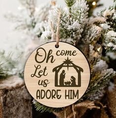 a wooden ornament hanging on a christmas tree that says, oh come let us adore him