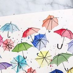 watercolor umbrellas are painted on a piece of paper