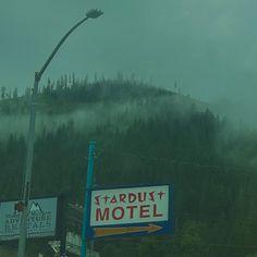 a motel sign in front of a mountain