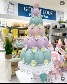 there is a cake made out of balloons and flowers on display in the store's window