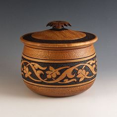 a wooden container with an intricate design on the lid