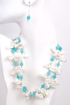 Dive into a sea of serenity with this Ocean Breeze necklace. The two strands of white Biwa pearls symbolize femininity and purity, while the matte turquoise rounds add a touch of color and vibrancy. Swarovski© crystal adds a touch of sparkle, making this necklace perfect for all occasions. The silver adjustable chain makes it easy to customize the length, so you can wear it any way you like. Soak up the sun and feel the sand between your toes while wearing this beautiful piece of jewelry. Turquoise Pearl Jewelry With Pearl Charm, Elegant Turquoise Pearl Jewelry With Pearl Charm, Elegant Double Strand Turquoise Beaded Necklace, Elegant Turquoise Double Strand Beaded Necklaces, Turquoise Pearl Drop Jewelry, White Multi-strand Jewelry With Natural Stones, Turquoise Jewelry With Pearl Chain And Round Beads, Elegant Turquoise Multi-strand Jewelry, Elegant Multi-strand Turquoise Jewelry