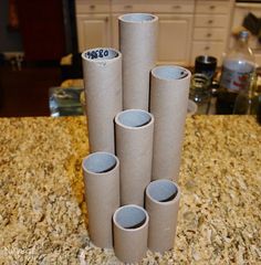 four rolls of toilet paper sitting on top of a counter next to a cup holder