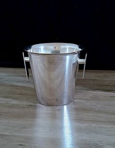 a metal bucket sitting on top of a wooden floor