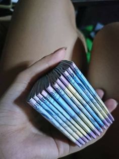 a person holding a bunch of colored pencils in their hand