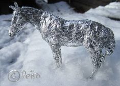 a horse made out of tin foil standing in the snow