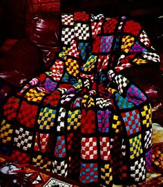 a multicolored blanket sitting on top of a couch