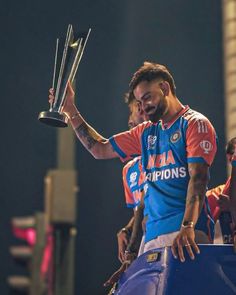 a man holding up a trophy while standing next to other people