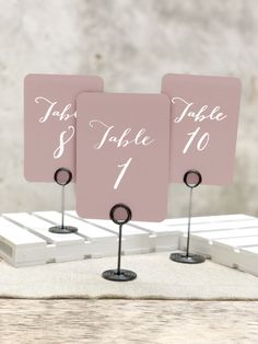 two pink place cards with black stand holders