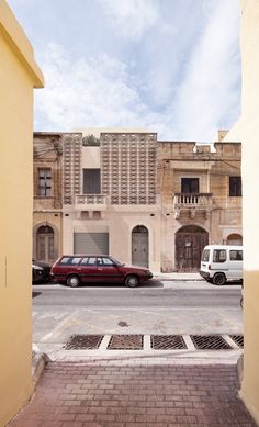 two cars are parked in front of an old building