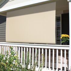 an outside view of a house with blinds on the porch and flowers in the window