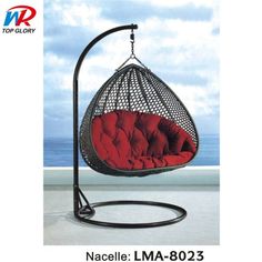 a hanging chair with red cushions on it