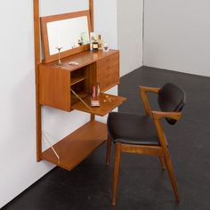 a wooden desk with a mirror and chair next to it