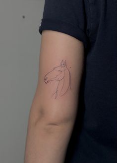 a person's arm with a horse tattoo on the left side of their arm