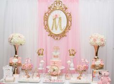 a pink and gold baby shower is set up with teddy bears, cake, decorations, and other items