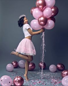 a woman in a pink tutu holding balloons