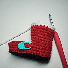 a crocheted red and white object with a blue hook on it's end