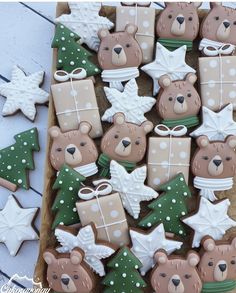 decorated cookies in the shape of christmas trees and teddy bears with bows, presents and stars