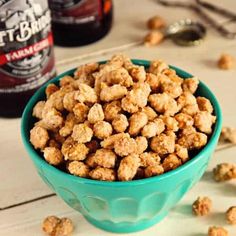 a blue bowl filled with cereal next to two bottles of beer