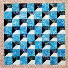 a blue and black quilt on the ground