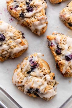 blueberry scones with icing on a baking sheet