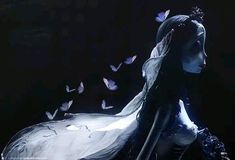 a woman with long hair and butterflies flying around her head, in the dark room