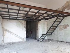 an unfinished room with a ladder in the ceiling and walls that have been stripped off