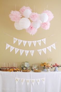 an image of a dessert table with pink and white decorations on the wall above it