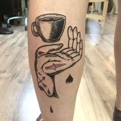 a tattoo on the leg of a person with a cup and saucer in it