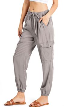 Light weight jogger pants with a high rise fit, a stretchy waist and an adjustable drawstring. Pockets at the sides and oversized pockets down the leg. Tapered elasticized ankle length. Baggy and comfortably fit. CARE | Hand Wash ColdCONTENTS | 100% Tencel MEASUREMENTS | 38"/97 cm Top to Bottom 26"/66 cm Inseam 12"/31 cm Rise (Size Small) MODEL | 5'8 - wearing a size SmallIMPORTED Spring Athleisure Cargo Pants With Tapered Leg, Sporty Spring Joggers For Elevated Casual Wear, Relaxed Fit Cargo Style Joggers For Loungewear, Casual Rayon Tapered Leg Pants, Spring Athleisure Parachute Pants With Tapered Leg, Spring Athleisure Tapered Leg Parachute Pants, Spring Cargo Style Relaxed Fit Joggers, Spring Cargo Style Sweatpants For Loungewear, Spring Athleisure Cargo Style Joggers