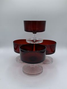 three glass dishes and one bowl are sitting on top of each other in front of a white background