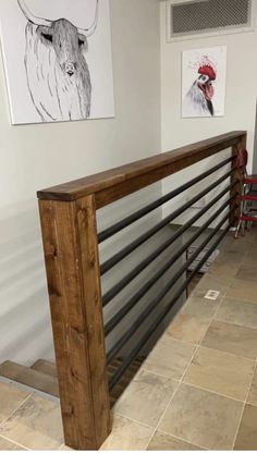 a metal and wood railing in a room with two pictures on the wall behind it