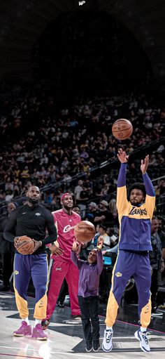 two basketball players are jumping up to dunk the ball in front of an audience