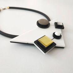 "Inspired by famous Piet Mondrian work, this is my interpretention of it. A monochromatic tones as opposed to Mondrian use of primary ones. Definitely a necklace for a stylish modern women! Lightweight necklace. * * * * * * * * * * * Materials: 0.24\"/6m\"m thick black silicon cord 0.12\"/3m\"m thick plexiglass resin acrylic colors Bib measurments: width: 4.7\"/12c\"m hight: 2.95\"/7.5c\"m maximum thicknes: 0.55\"/14m\"m Like wearing a set? check out shop's Clip On Earrings section: https://www. Modern White Long Necklace, Modern Long Necklace For Party, Bold White Jewelry For Gift, Bold White Jewelry For Gifts, Elegant Geometric White Jewelry, Elegant White Geometric Jewelry, Contemporary Handmade Necklace, Modern Handmade Necklaces For Party, Modern Pendant Necklace With Unique Variations