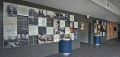 an empty hallway with many pictures on the wall and blue pedestals in front of it