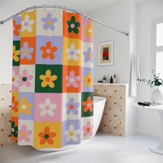 a colorful shower curtain with flowers on it in a white bathroom next to a bathtub