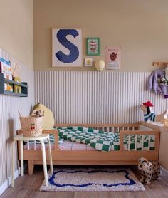 a child's room with a bed, rugs and pictures on the wall