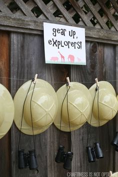 there are many yellow and black hats hanging on the wall with a sign that says, gear up explorers