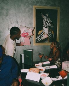 a group of people sitting around a table with food and drinks in front of them