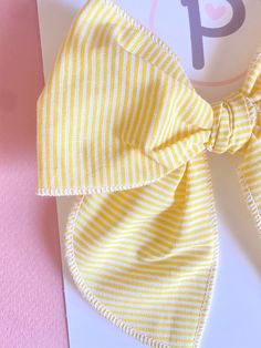 Yellow Striped Pattern  Fabric: Cotton  Sizing: - Mini: 4.5" x 4.5" - Regular: 5" x 5.5"  All items are handmade, and may contain slight variations in fabric placement. Due to different monitors and devices, colors way vary slightly. I recommend only baby or mini on nylon WARNING:  CHOKING HAZARD - Small parts Clips are not intended for children under 3 years old. It is recommended that all products should be used with adult supervision. Summer Decorative Bow Headband, Summer Bow Headband, Playful Bow Hair Accessories For Summer, Playful Bow Headband Hair Accessory, Playful Summer Hair Accessories With Bow, Playful Adjustable Bow For Summer, Adjustable Playful Bow For Summer, Adjustable Bow With Matching Headband For Spring, Playful White Decorative Bow