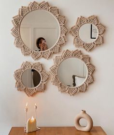 three circular mirrors on the wall above a table with candles and a candle holder next to it