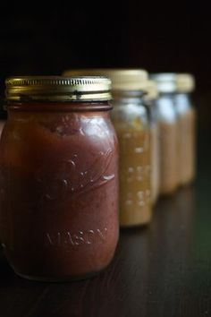 three jars filled with food sitting on top of a table