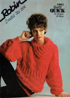 a young man sitting on the ground wearing a red sweater