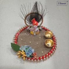 a small decorative item with beads and flowers on it's side, sitting on top of a table