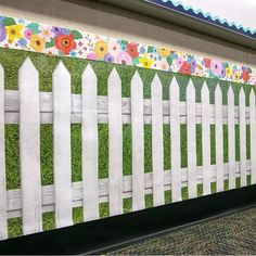 a white picket fence with flowers painted on it