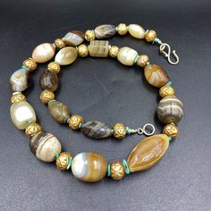 The Rare and Unique Himalayan Indo Tibetan Solumani Banded Agate Beads Necklace Mala The Age of this Beads are More than 1000 Years Old It was Used as Prayer Beads In Prayer Malas and Used as Amulet Beads It was Used In Ancient Times as Jewelry and Used as trade Item as well Some Gold Plated Wax and Turquoise Beads are Used as Spacers Fast and Free Shipping Service Enjoy Traditional Gold Agate Necklace, Luxury Agate Gemstone Beaded Necklaces, Traditional Gold Agate Beaded Necklaces, Traditional Agate Gemstone Beaded Necklaces, Traditional Agate Beaded Necklaces With Gemstones, Traditional Agate Beaded Necklace With Gemstones, Traditional Agate Gemstone Necklace, Artisan Gemstone Beaded Necklace, Artisan Beaded Necklace With Oval Gemstones