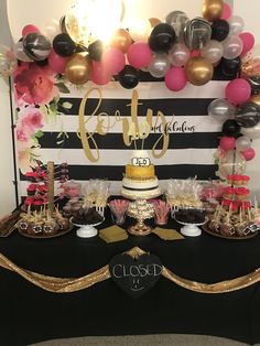 a black and gold dessert table with balloons