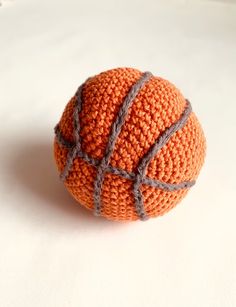 an orange crocheted ball sitting on top of a white table